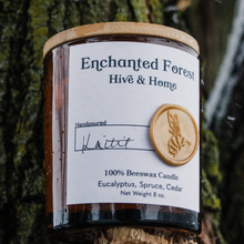 Load image into Gallery viewer, Enchanted Forest amber glass candle on a broken branch of a tree while it's snowing.