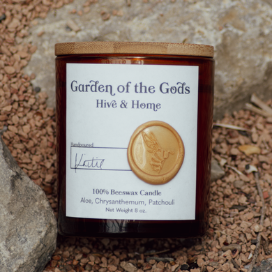 Our Garden of the Gods apothecary beeswax candle by rocky terrain.